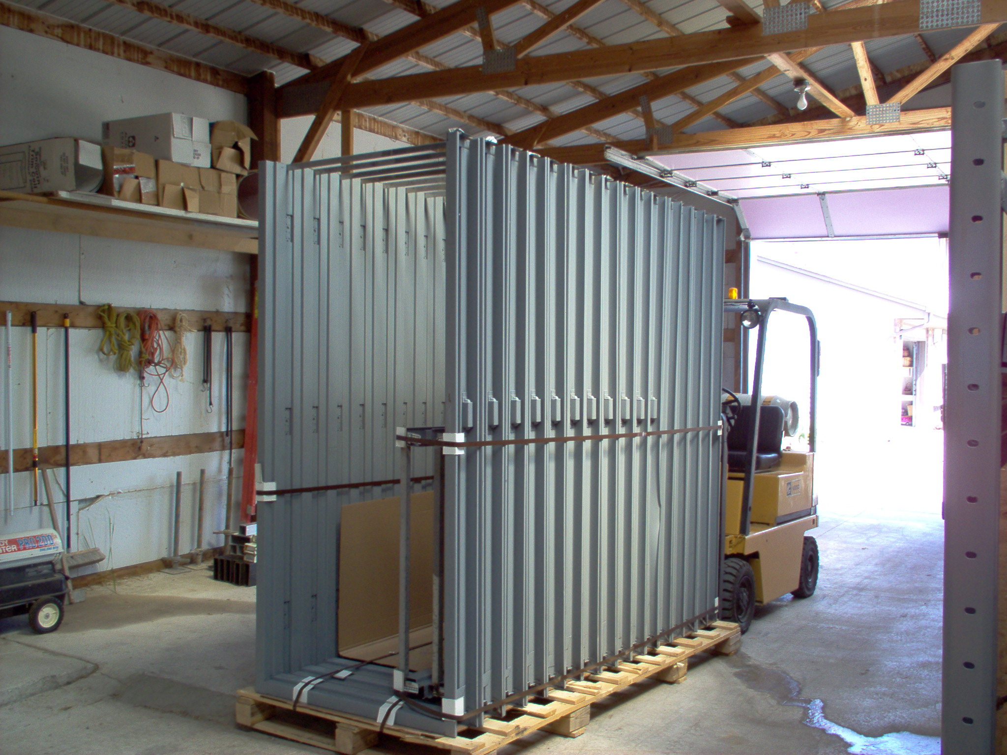 A forklift is parked in front of a metal fence.