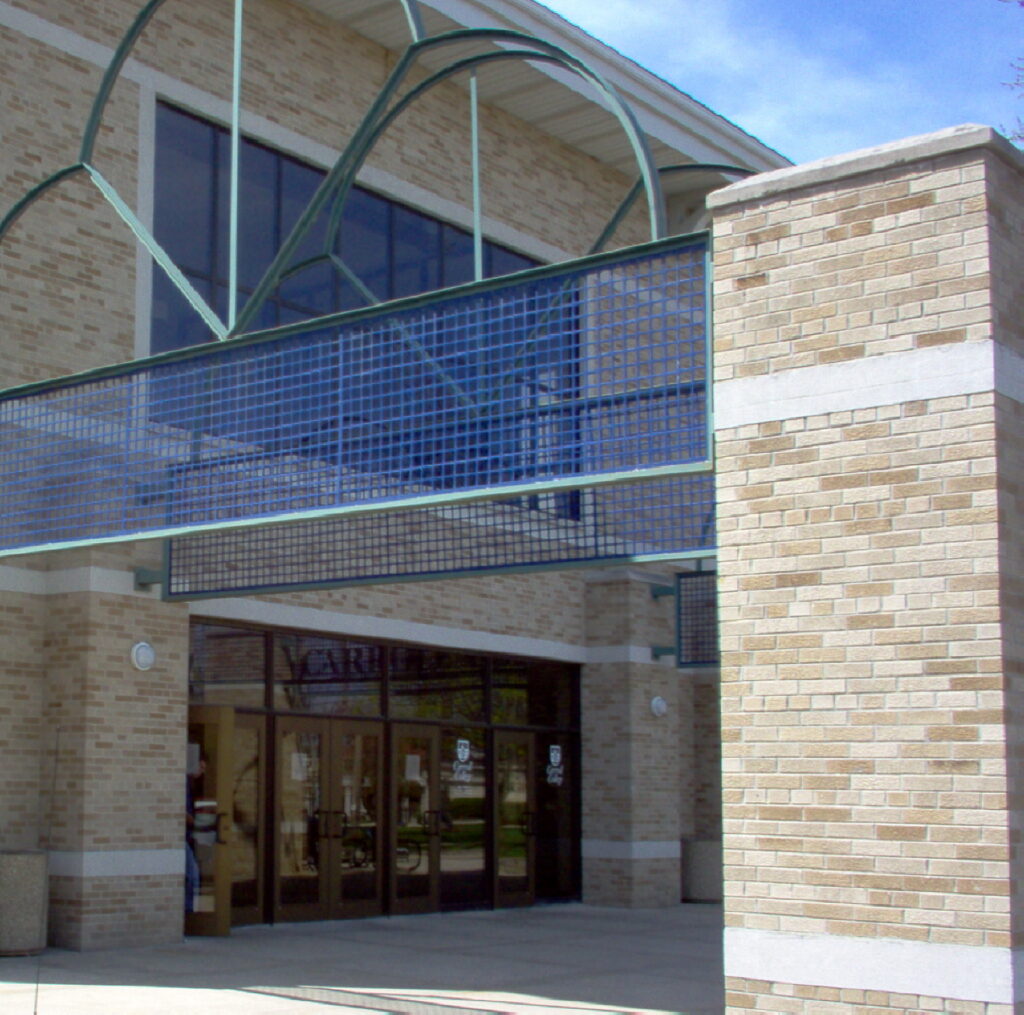 A building with a large glass window and brick wall.